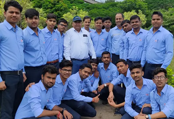 Prism Johnson employees in blue uniforms posing for an outdoor group photo during a training and development programme