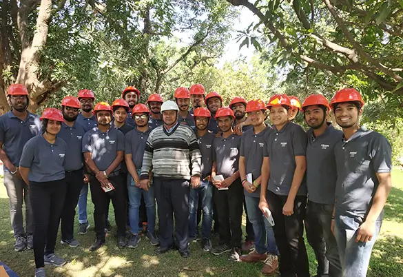 Group of employees wearing safety helmets during an outdoor industrial safety training session